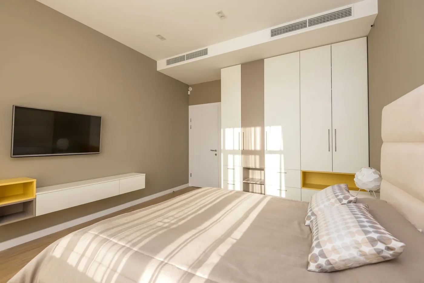 A calm bedroom with neutral bedding and natural light