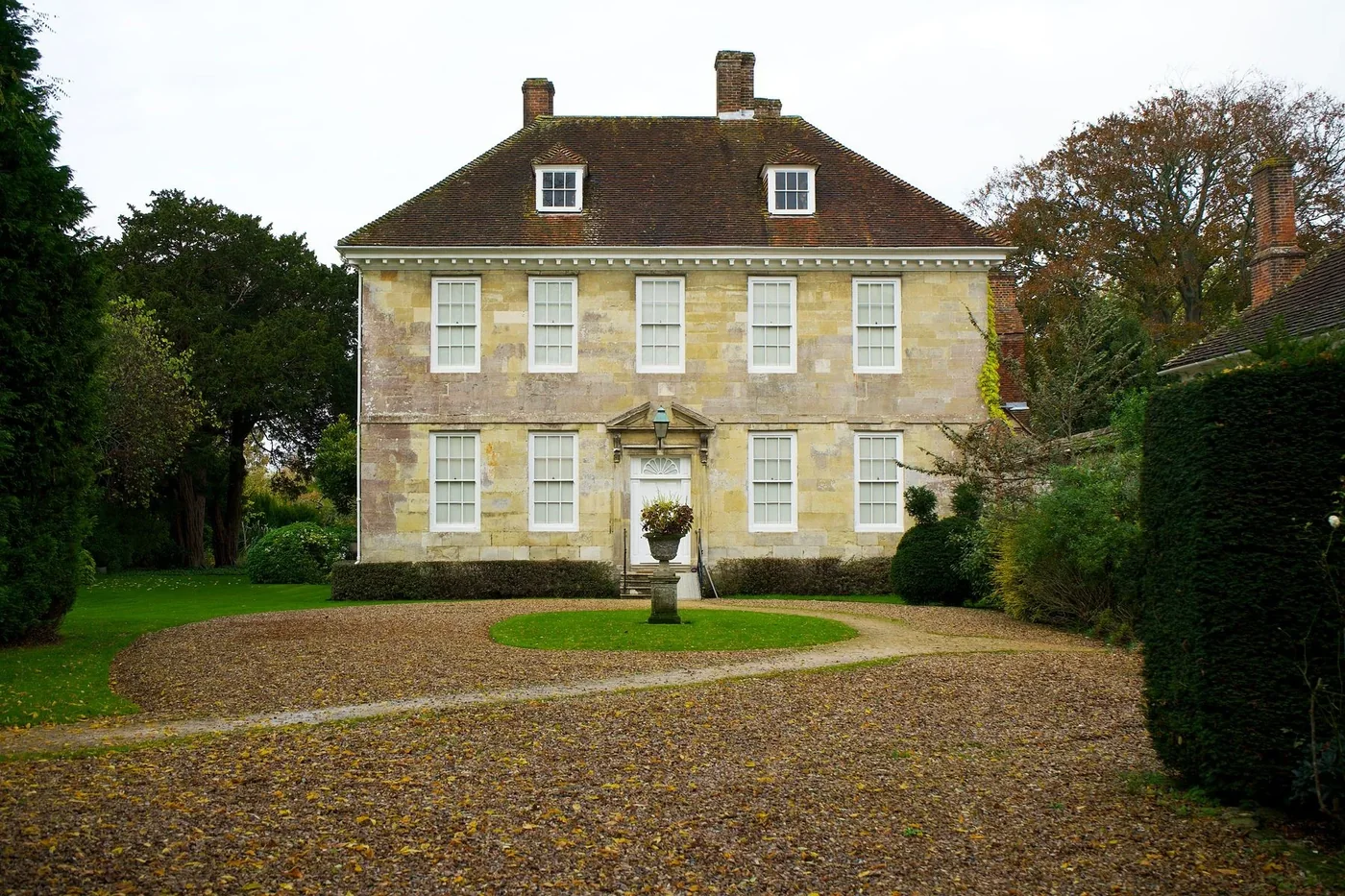 A welcoming country house surrounded by mature trees and a garden