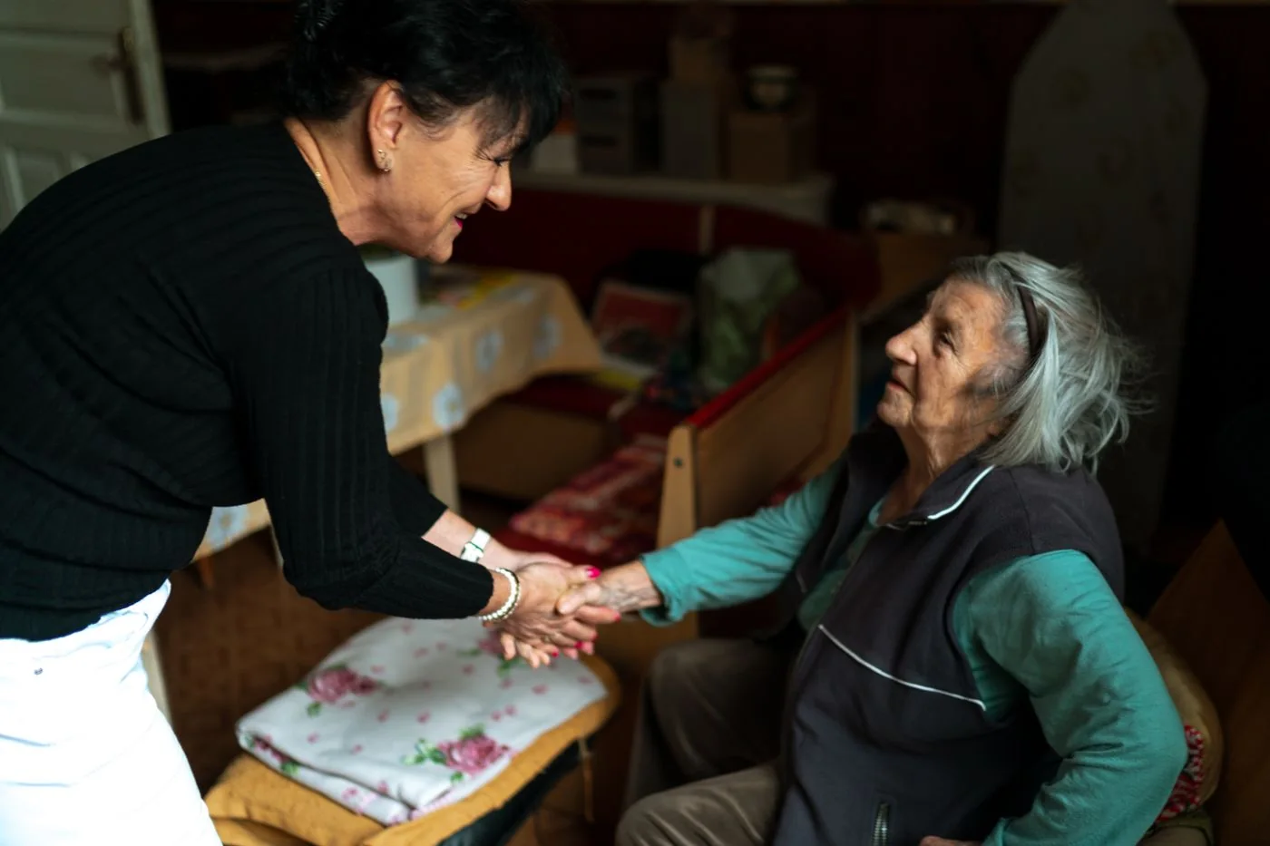 A care worker warmly greeting an older woman