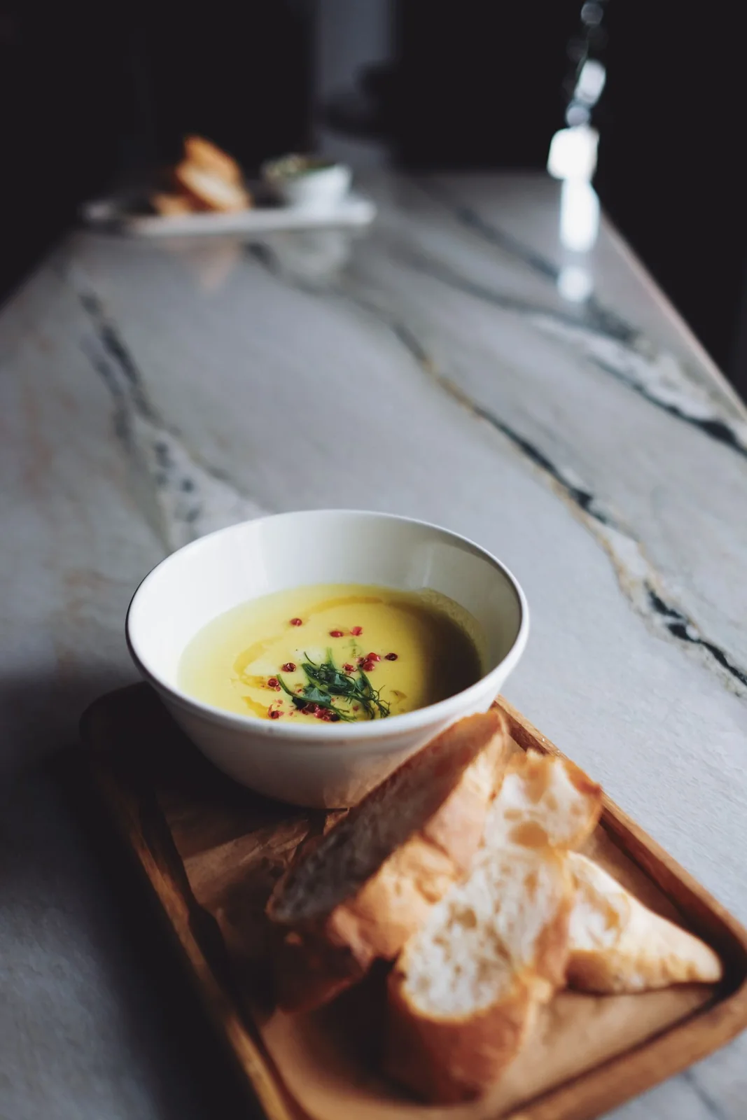 A bowl of soup served with fresh bread